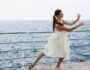 Young beautiful ballerina dancing and posing outside, sea background. Young beautiful ballerina dancing and posing outside, sea background.