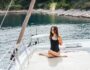 Young healthy and calm woman doing yoga on sailing yacht boat in sea at island background Young healthy and calm woman doing yoga on sailing yacht boat in sea at island background