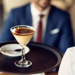 Close-up of waitress serving dessert to a guest in a cafe.