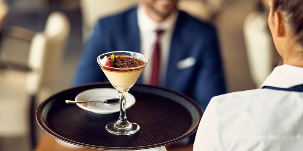 Close-up of waitress serving dessert to a guest in a cafe. Close-up of waitress serving dessert to a guest in a cafe.